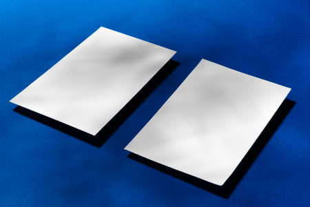 Two stacks of blank businesscards on blue backgroundの写真素材