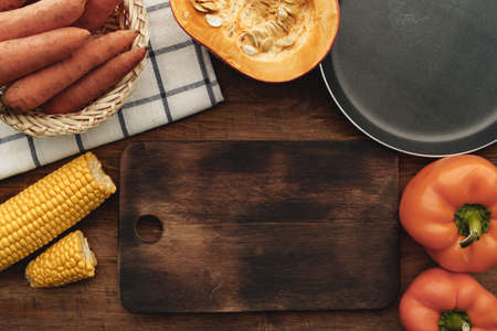 Top view of pumpkin, carrots and corn on wooden tableの写真素材