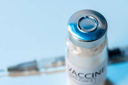 Vial of vaccine bottle with a syringe close up