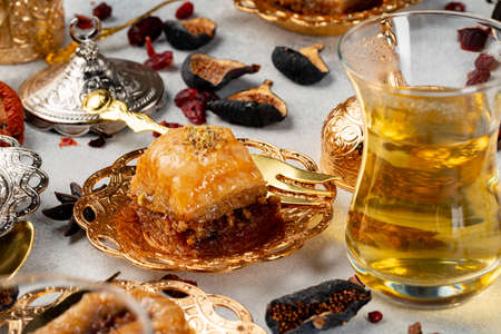 Piece of Turkish baklava in golden arabic plate