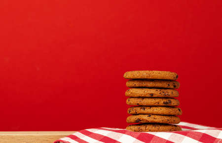 Chocolate chip cookies in stack on red backgroundの写真素材