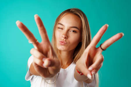 Young happy smiling woman showing victory sign.の写真素材