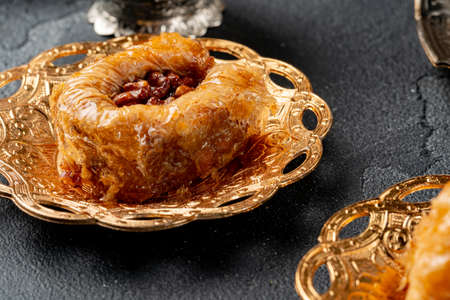 Piece of Turkish baklava in golden arabic plateの写真素材