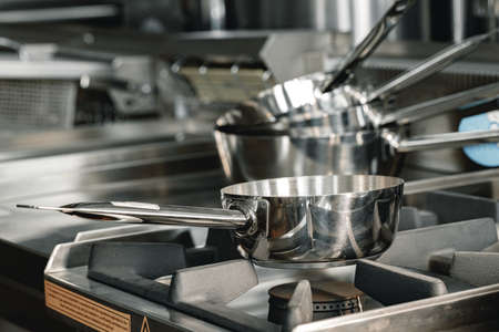 Stacked industrial metal cooking pots on proffesional kitchenの写真素材