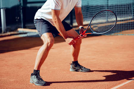 Tennis player standing in ready position on tennis courtの写真素材