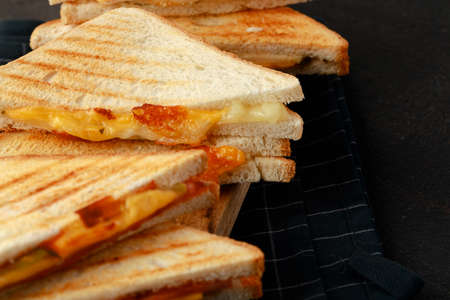 Sandwiches cut into halves on wooden cutting board with napkinの写真素材