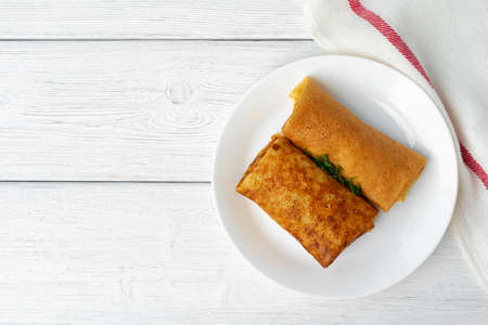 Two fried russian pancakes on white wooden table