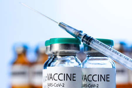 Covid-19 vaccine bottle with a syringe on lab tableの写真素材