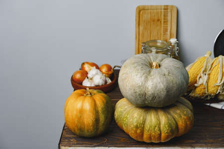 Pumpkins on kitchen table against grey wall