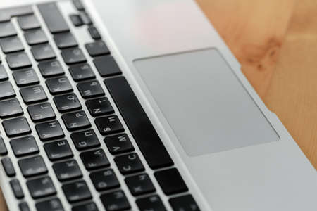 Keyboard of a laptop on wooden table close up