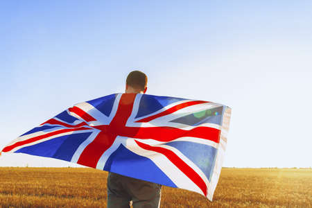 Man with a flag of Great Britain standing in fieldの写真素材