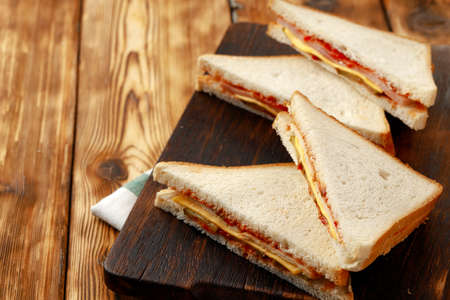 Sandwiches cut into halves on wooden cutting board with napkinの写真素材