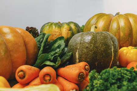 Pile of pumpkins, carrots and leek on tableの写真素材