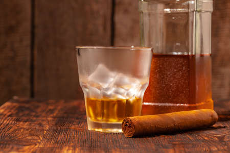 One glass of whisky and cigar on wooden tableの写真素材
