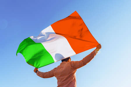 Man with a flag of Italy standing in fieldの写真素材