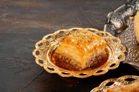 Piece of Turkish baklava in golden arabic plateの写真素材
