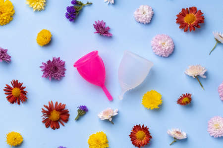 Menstrual cup on floral pattern background top viewの写真素材