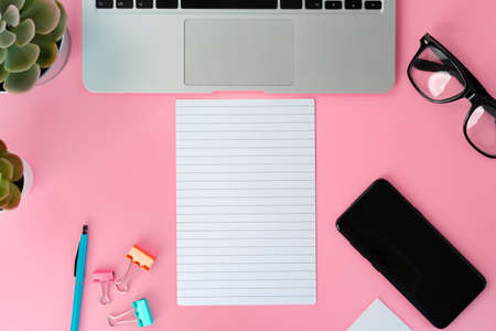 Top view of laptop and notepad on tableの写真素材