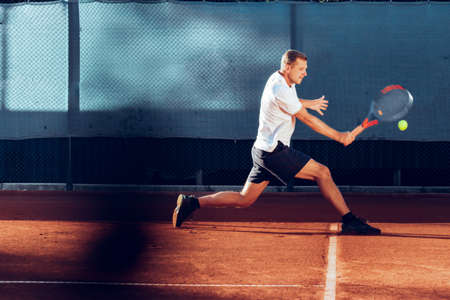 Proffesional tennis player beats off a ball during matchの写真素材