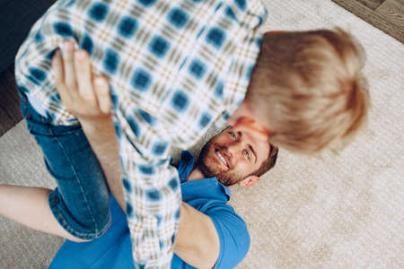 Father and son playing together on carpet at home