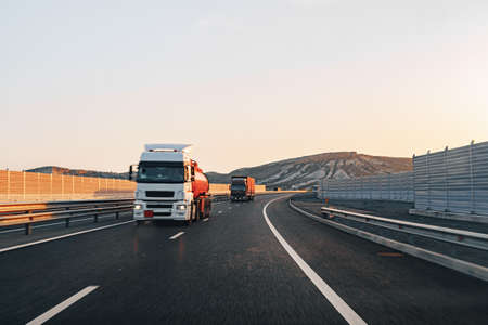 Truck driving on highway road at sunriseの写真素材