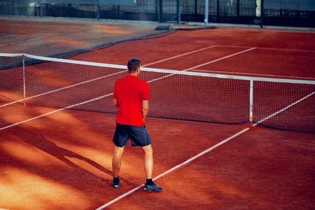 Back view of a man playing tennis on tennis courtの写真素材
