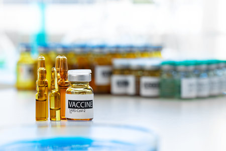 Vaccine in vial for injection on table against background of laboratoryの写真素材