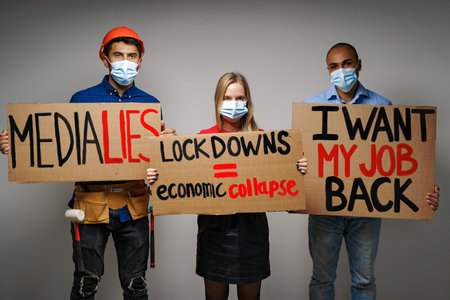 Group of protesters standing with placards against lockdownsの写真素材