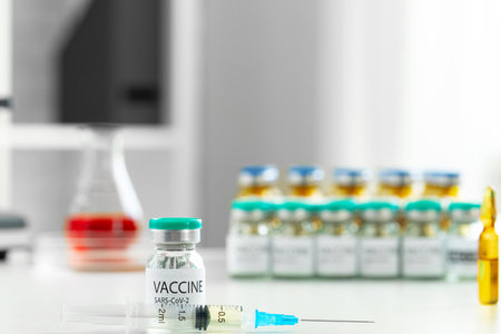 Vaccine in vial for injection on table against background of laboratoryの写真素材