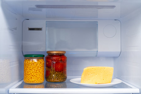 Glass jars of canned products on a fridge shelfの写真素材