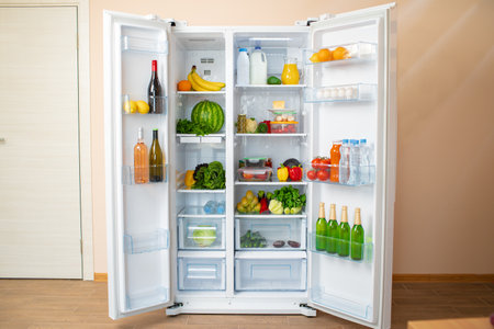 Open fridge full of fruits, vegetables and drinksの写真素材