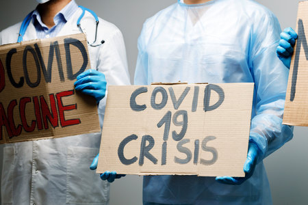 Covid-19 crisis placard in hands of protesterの写真素材
