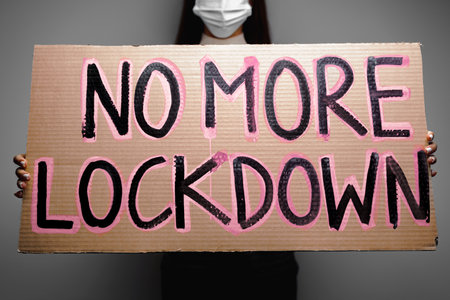Protestive placard against coronavirus lockdowns against wallの写真素材