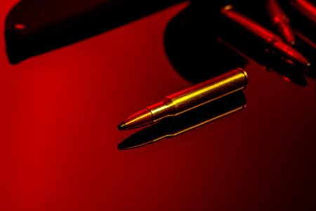 Rifle cartridges on glass background in red lightの写真素材