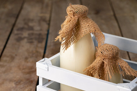 Two bottles of milk in wooden box on wooden backgroundの写真素材