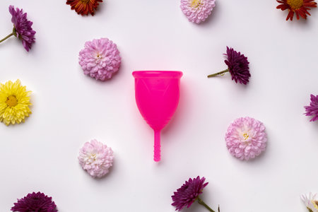 Menstrual cup on floral pattern background top viewの写真素材