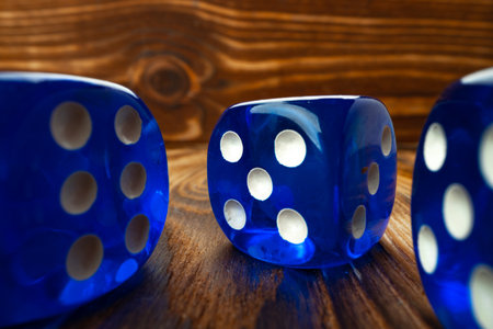 Blue dice cubes against brown wooden background close upの写真素材