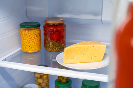 Glass jars of canned products on a fridge shelfの写真素材