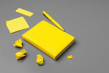 Yellow notepad on gray background close upの写真素材