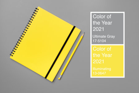 Yellow notepad with yellow pencil on gray backgroundの写真素材