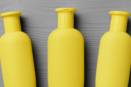 Yellow cosmetic container on gray background top view