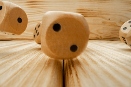 Wooden dice tossed on wooden background close upの写真素材