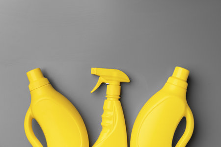 Yellow liquid detergents containers on gray background