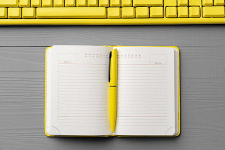 Yellow notepad on gray wooden background top viewの写真素材