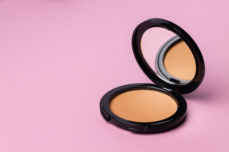 Compact face powder on pink background front viewの写真素材