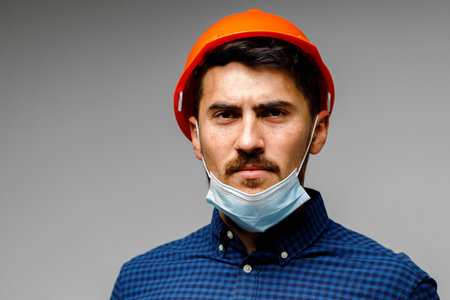 Construction worker with protective mask portrait on grey background