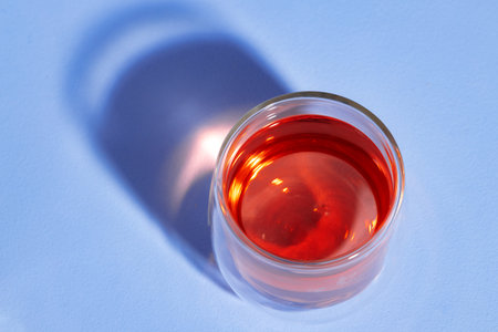 Glass cup of tea on blue background