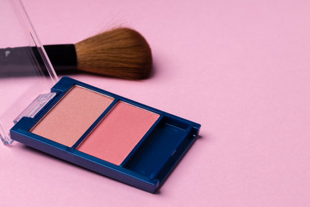Make up palette with brush on pink background