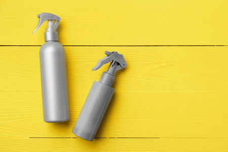 Gray cosmetic bottle on yellow wooden backgroundの写真素材