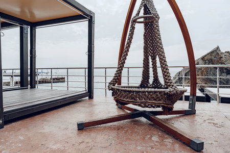 Woven swing on luxury hotel terrace near sea